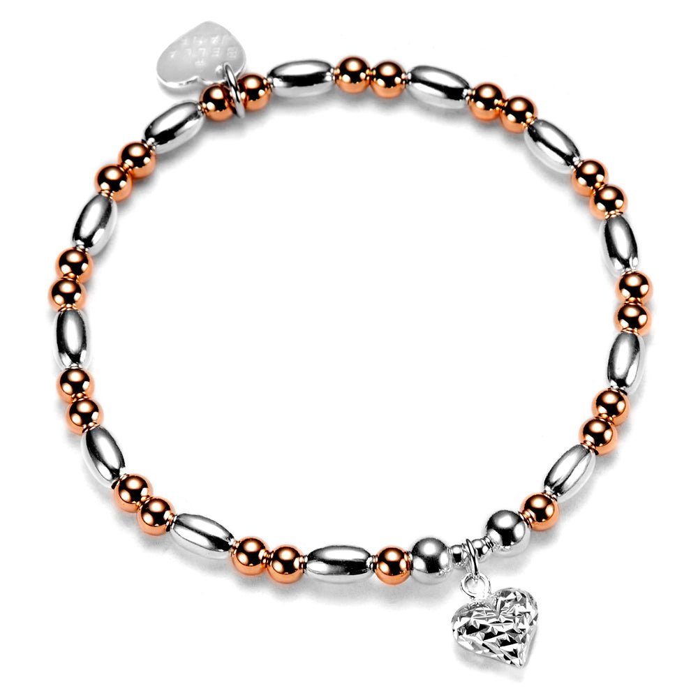 Bracelet with silver and rose gold beads and a silver faceted heart charm on a white background