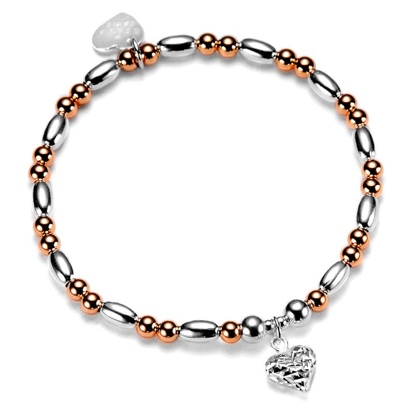 Bracelet with silver and rose gold beads and a silver faceted heart charm on a white background