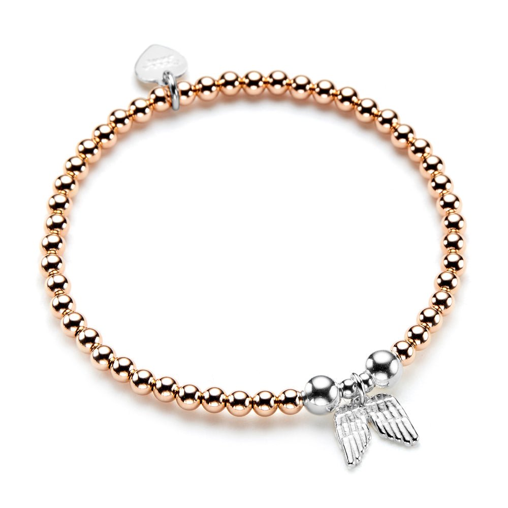 A rose gold beaded bracelet with a silver angel wing charm on a white background.