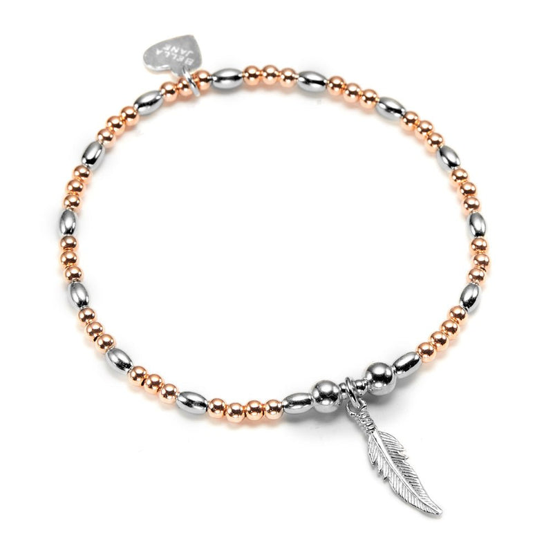 Bracelet with rose gold and silver beads and a silver feather charm on a white background