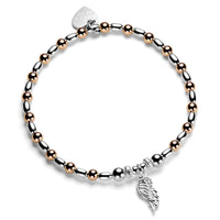 Bracelet with rose gold and silver beads and a single angel wing charm on a white background