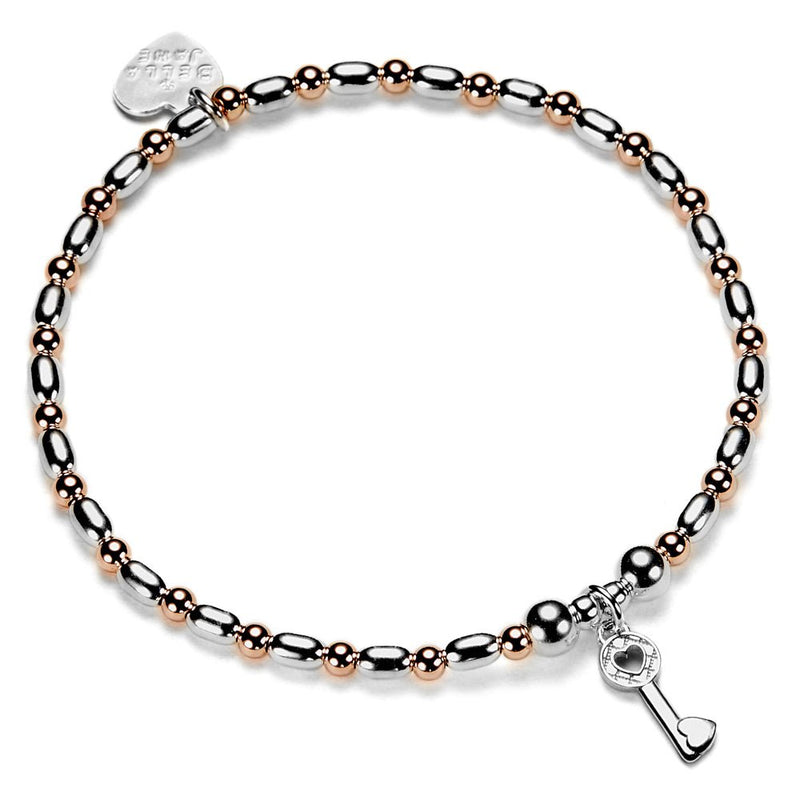 Bracelet with rose gold and silver beads and a silver key charm on a white background