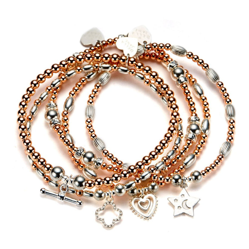 Set of five rose gold and sterling silver beaded bracelets with charms on a white background