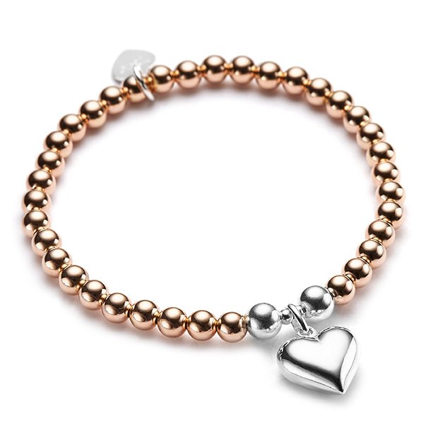 Rose gold and silver beaded bracelet with a silver heart charm on a white background