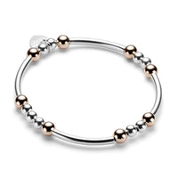 Sterling silver and rose gold beaded bracelet with noodle shaped and round beads on a white background