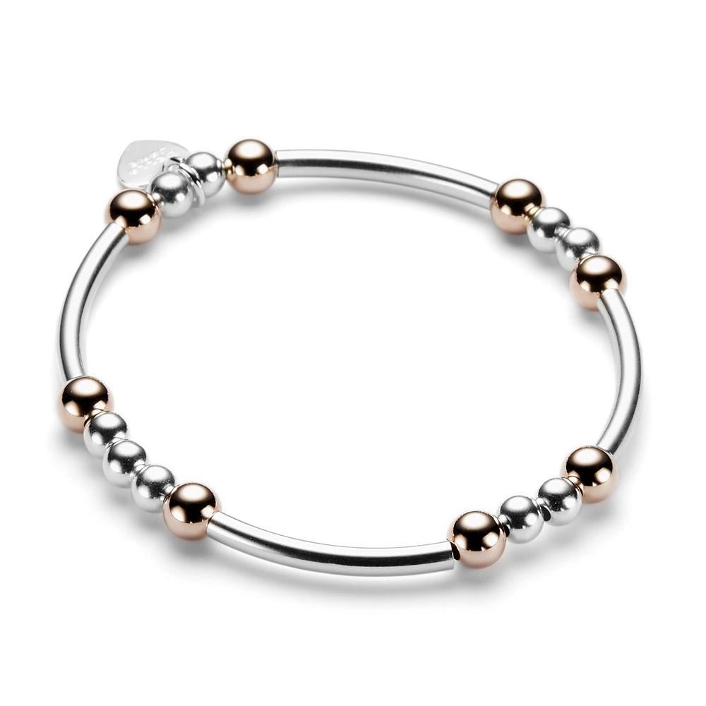 Sterling silver and rose gold beaded bracelet with noodle shaped and round beads on a white background