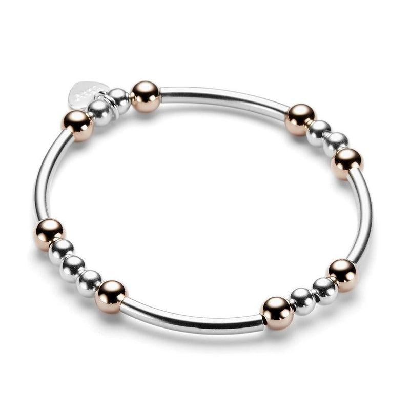 Sterling silver and rose gold beaded bracelet with noodle shaped and round beads on a white background