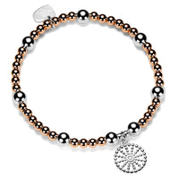 Bracelet with rose gold and silver beads with a silver bobble disc shaped charm on a white background