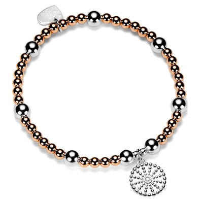 Bracelet with rose gold and silver beads with a silver bobble disc shaped charm on a white background
