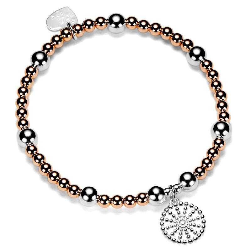 Bracelet with rose gold and silver beads with a silver bobble disc shaped charm on a white background