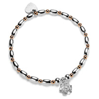 Silver and rose gold mixed metal beaded bracelet with a sterling silver flower charm, on a white background