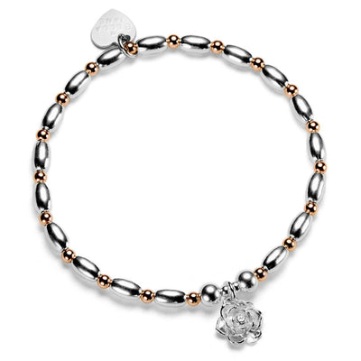 Silver and rose gold mixed metal beaded bracelet with a sterling silver flower charm, on a white background