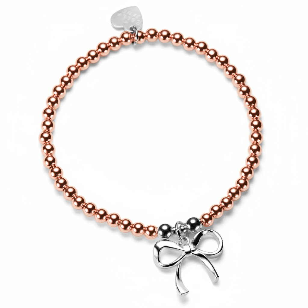 Rose gold beaded bracelet with a silver bow charm on a white background