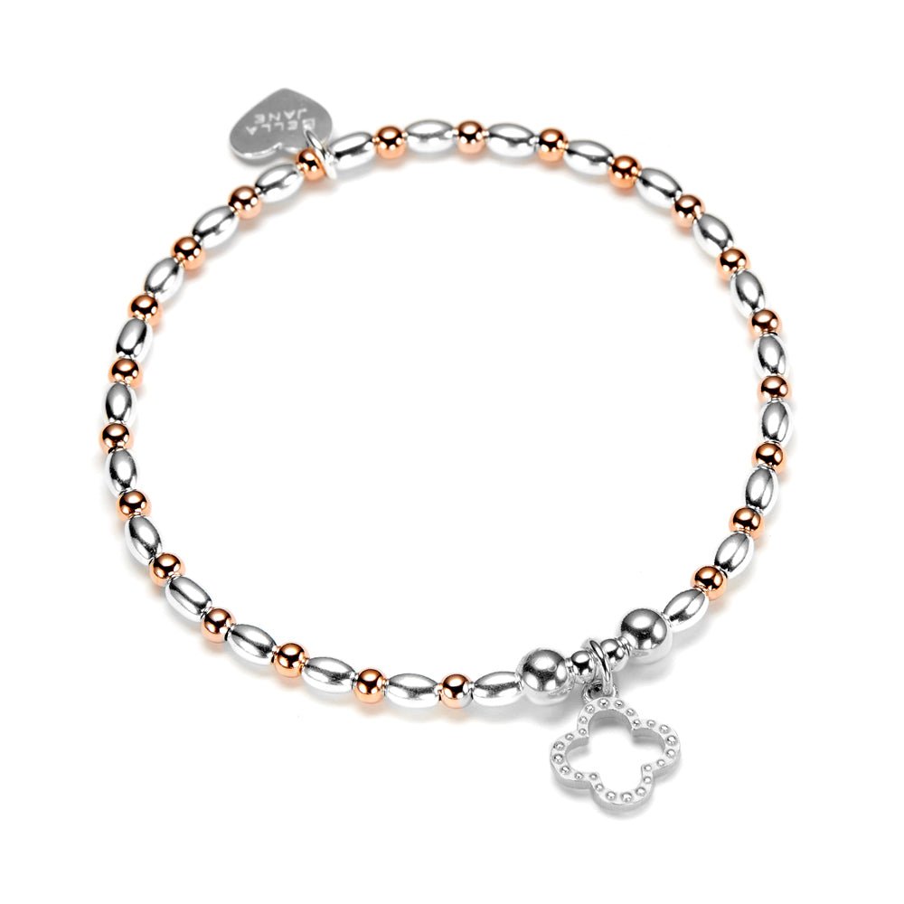 Rose gold and silver beaded bracelet with a clover charm on a white background.