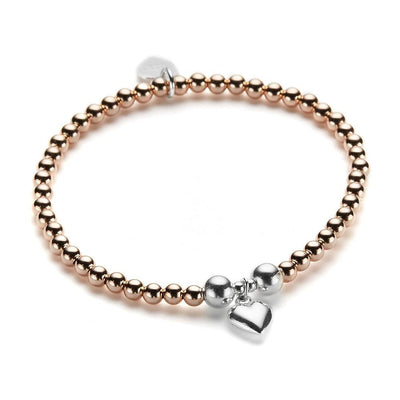 Rose gold and silver beaded bracelet with a silver heart charm on a white background