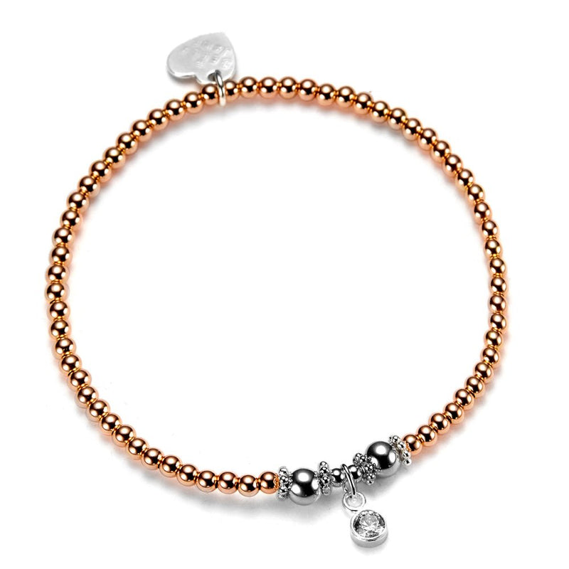 Rose gold beaded bracelet with silver sparkle charms on a white background