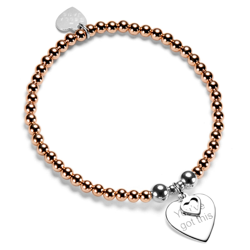 Rose gold beaded bracelet with silver heart charms, featuring the words 'you've got this' on a white background