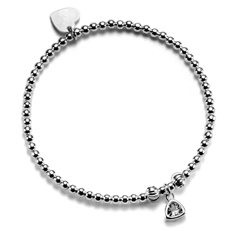 A close up of a handmade beaded bracelet featuring a cubic zirconia birthstone charm to represent April