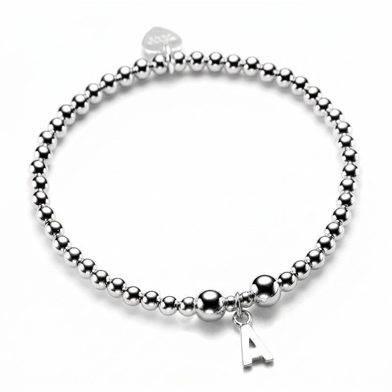 Sterling silver beaded stacking bracelet with a sterling silver initial 'A' charm, on a white background
