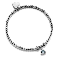 A close up of a handmade beaded bracelet featuring an aquamarine coloured birthstone charm to represent March