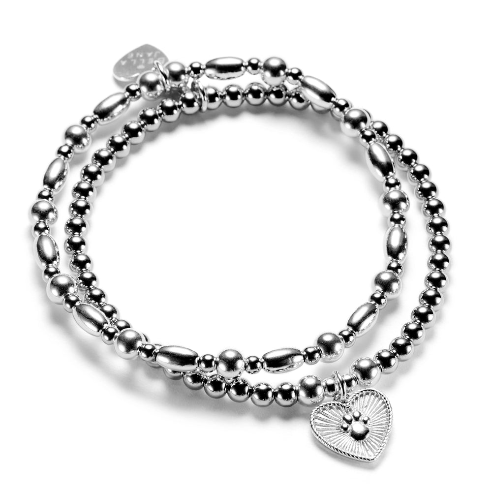 Silver beaded stacking bracelet duo with one bracelet featuring a paw print heart charm, on a white background