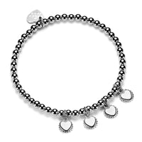 A sterling silver ball bead bracelet with four disc charms, each engraved with an initial, displayed against a white background.