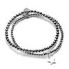 A silver stacking bracelet duo with one plain stacking bracelet and one featuring a silver star charm, on a white background