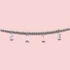 A row of silver beads with initial charms hanging spelling the word 'SALE' against a pink background