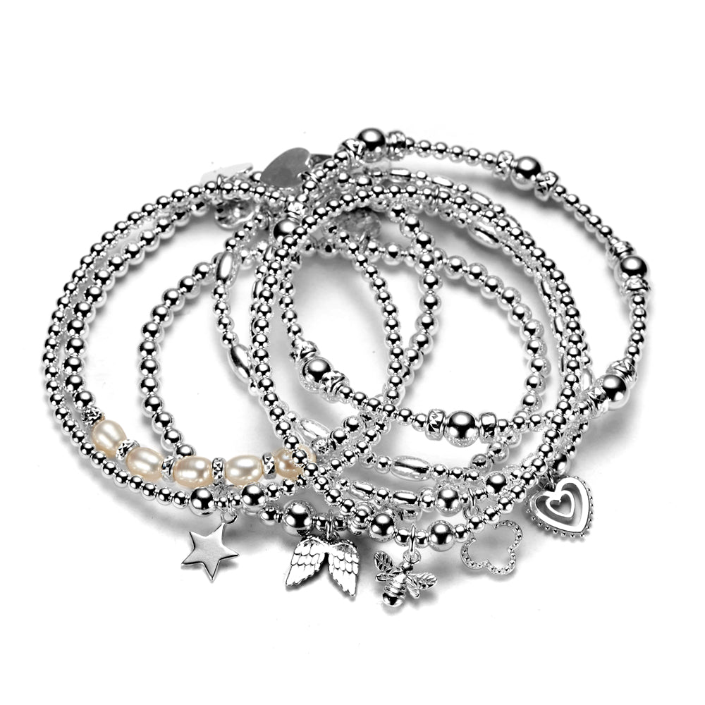 A set of seven sterling silver bracelets with various charms, including a heart and stars, displayed together.
