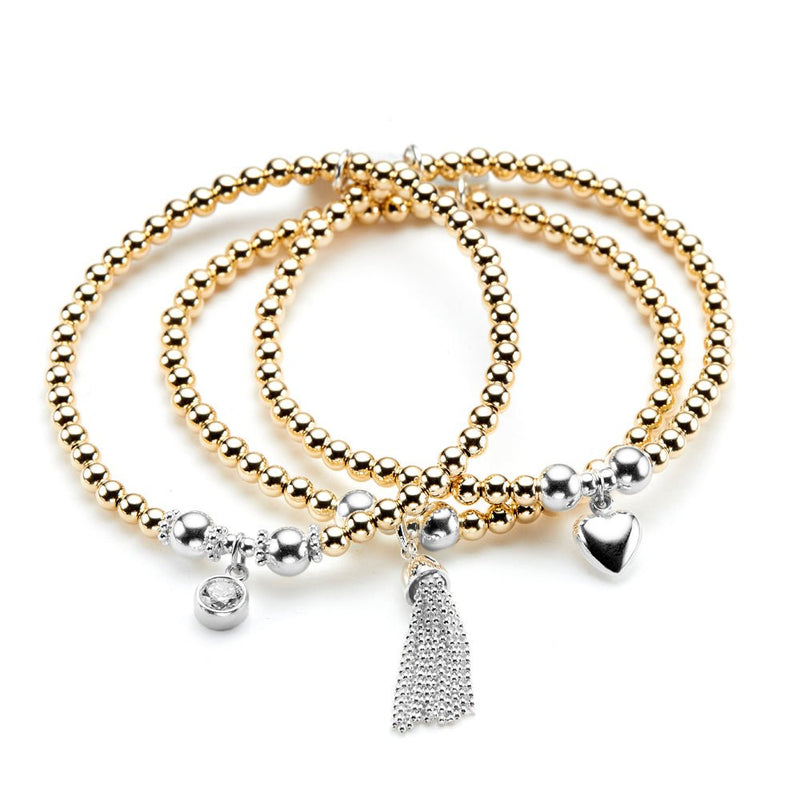 Set of gold and silver beaded bracelets with charms on a white background