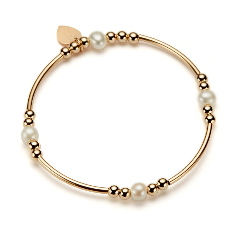 Gold beaded bracelet with noodle and round shaped beads, with freshwater pearls, on a white background
