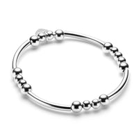 Sterling silver beaded bracelet with noodle shaped and round beads on a white background
