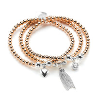 Set of rose gold and silver beaded bracelets with charms on a white background