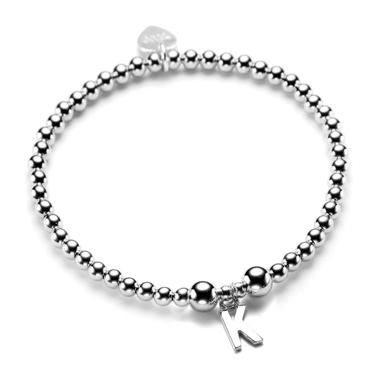 Sterling silver beaded stacking bracelet with a sterling silver initial 'K' charm, on a white background