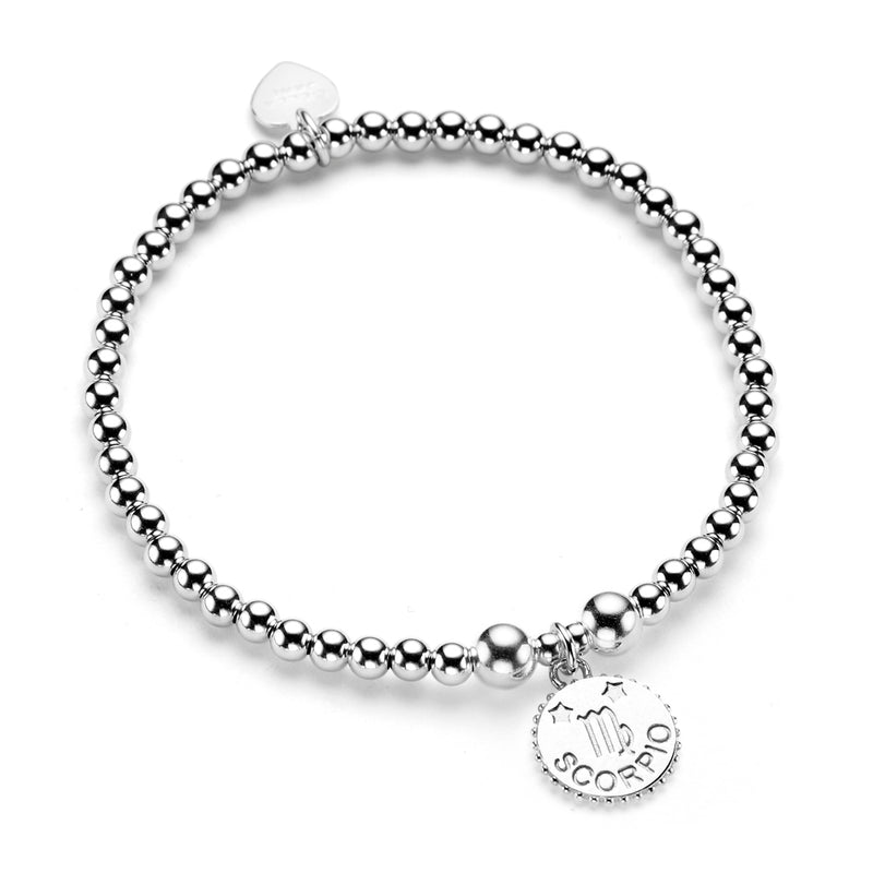 A sterling silver bracelet featuring small ball beads and a disc charm with the Libra zodiac symbol, against a white background