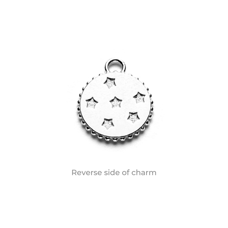 Reverse side of the Bella Jane sterling silver zodiac charm, featuring seven tiny stars, displayed on a white background